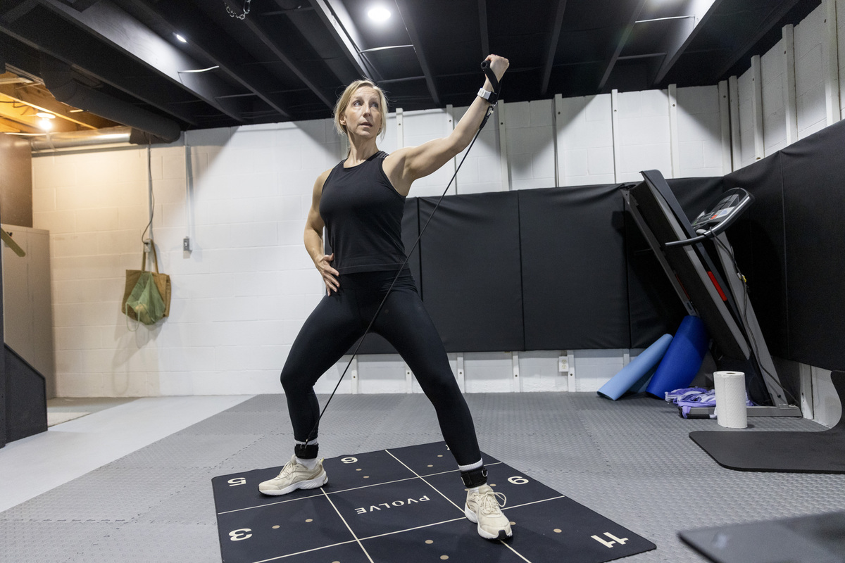 Sarah Dunay, 45, exercises at home in Perry, Ohio, May 17, 2026. Dunay exercises five days a week using a menopause workout program. "I can't say enough about how confident I feel in my body," she said. (Maddie McGarvey/The New York Times)