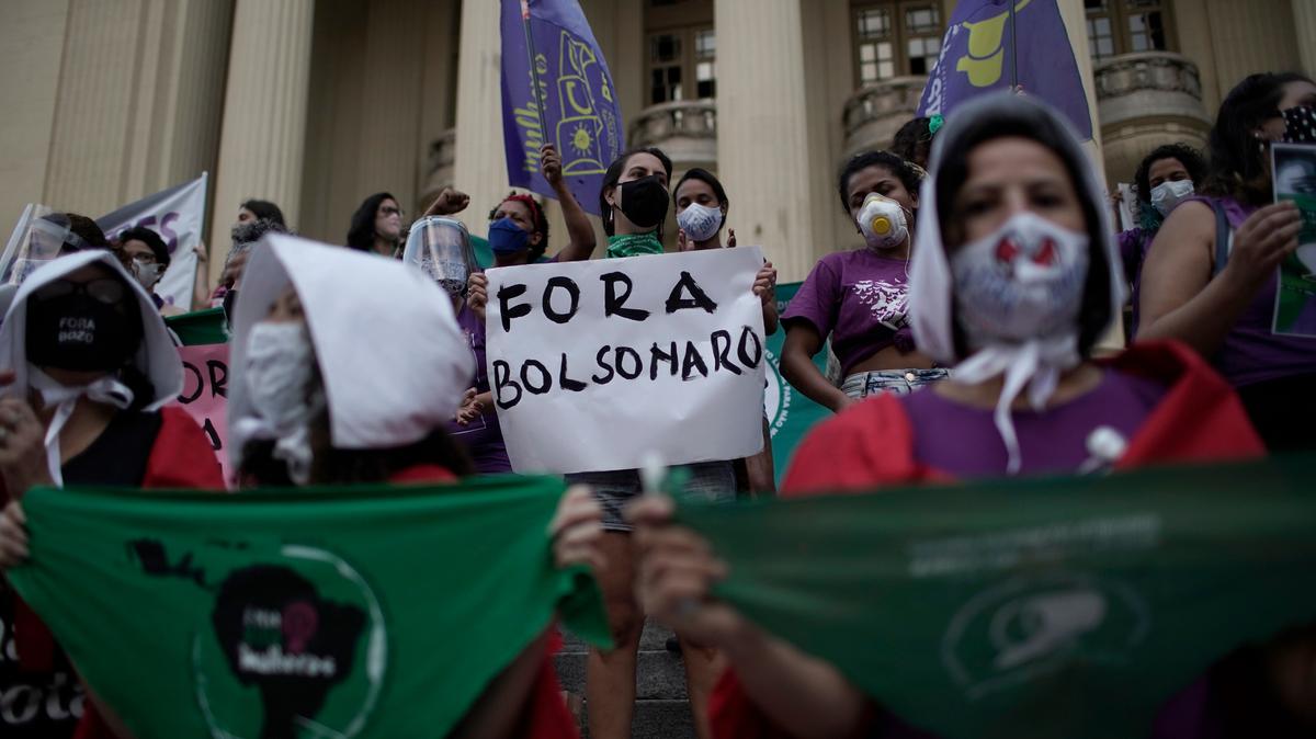 ARCHIVO - En esta foto de archivo del 28 de septiembre de 2020, activistas a favor de la legalización del aborto se manifiestan y una sostiene una pancarta con la leyenda en portugués “Fuera Bolsonaro” durante una protesta afuera de la asamblea legislativa en Río de Janeiro, en Brasil.