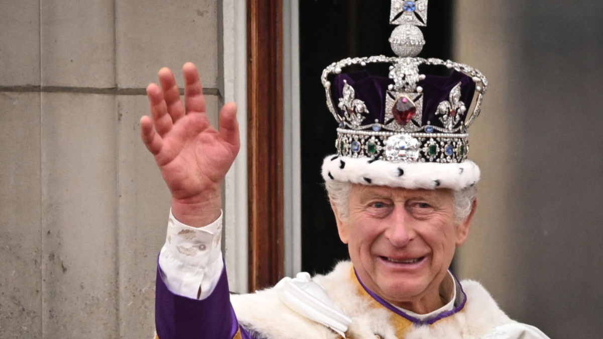 Britain's King Charles III wearing the Imperial state Crown, waves from the Buckingham Palace balcony after viewing the Royal Air Force fly-past in central London on May 6, 2023, after his coronation. 