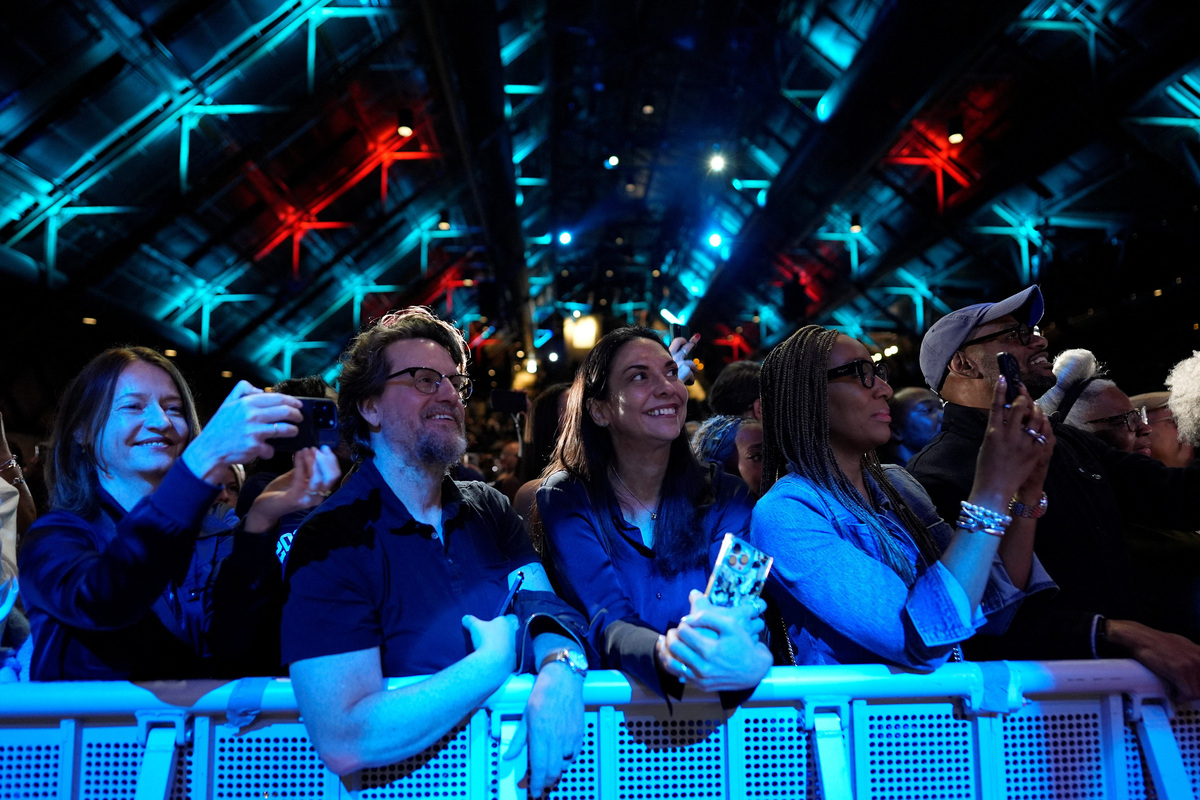 People listen to former president Barack Obama and former first lady Michelle Obama's speech as they surprised administration and campaign alumni in Chicago ahead of the dedication ceremony of the Obama Presidential Center, Wednesday, June 17, 2026.     Pablo Martinez Monsivais/Pool via REUTERS