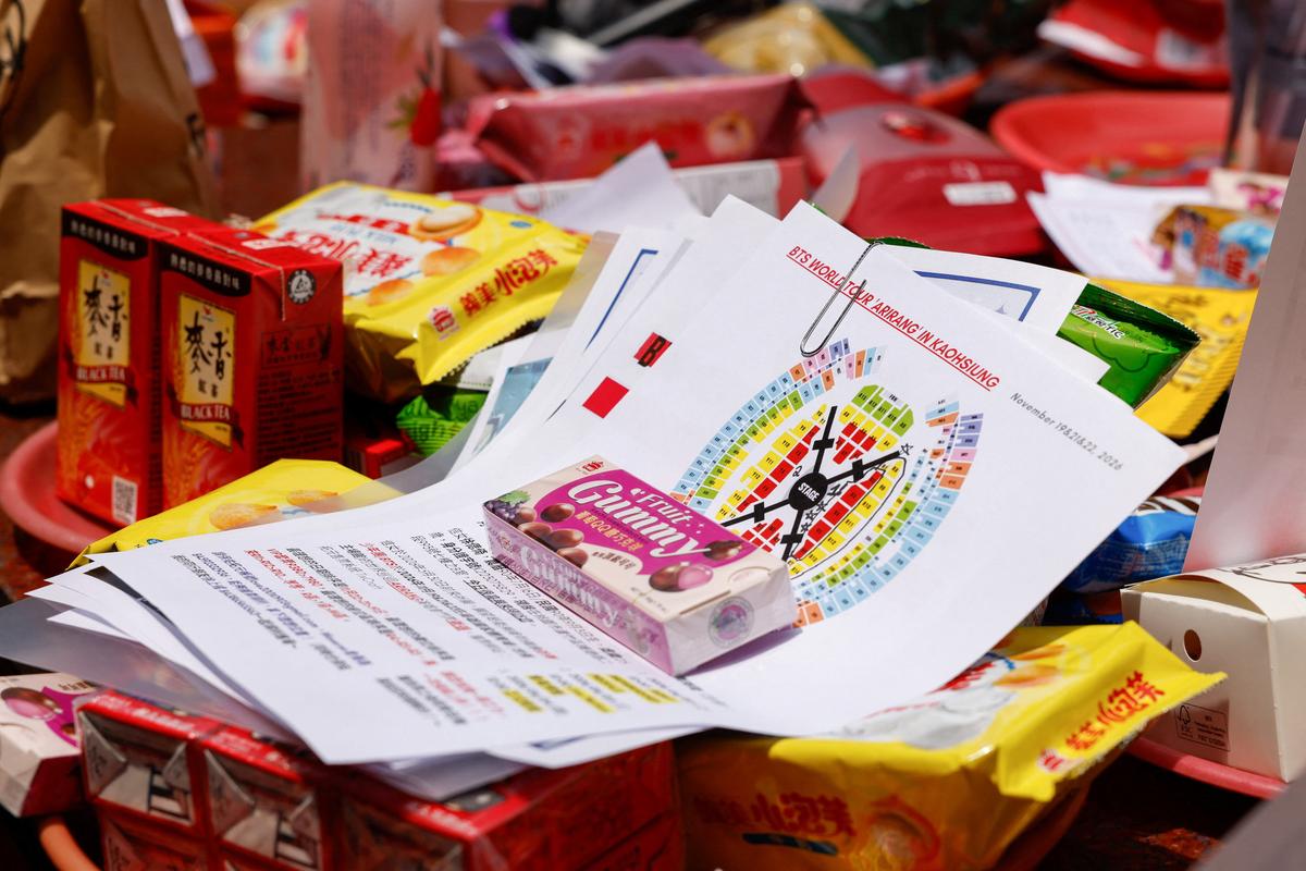 Offerings of snacks with BTS merchandise, concert seat maps and wish lists are seen on an altar table for Yue Lao, the god of love in Chinese mythology who oversees relationships and marriage, at Taipei’s Bangka Lungshan Temple, in hopes of securing a concert ticket, in Taipei, Taiwan, May 30, 2026. REUTERS/Ann Wang