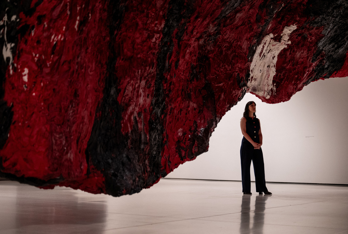 A gallery assistant poses for a photograph next to Anish Kapoor's installation 'Mount Moriah at the Gate of the Ghetto' (2022) during the press view for 'Anish Kapoor' at the Hayward Gallery, in London, Britain, June 15, 2026. REUTERS/Chris J. Ratcliffe