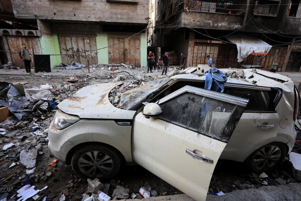 Palestinians stand near a damaged car, at the site of an Israeli strike on an apartment in Gaza City June 4, 2026. REUTERS/Dawoud Abu Alkas