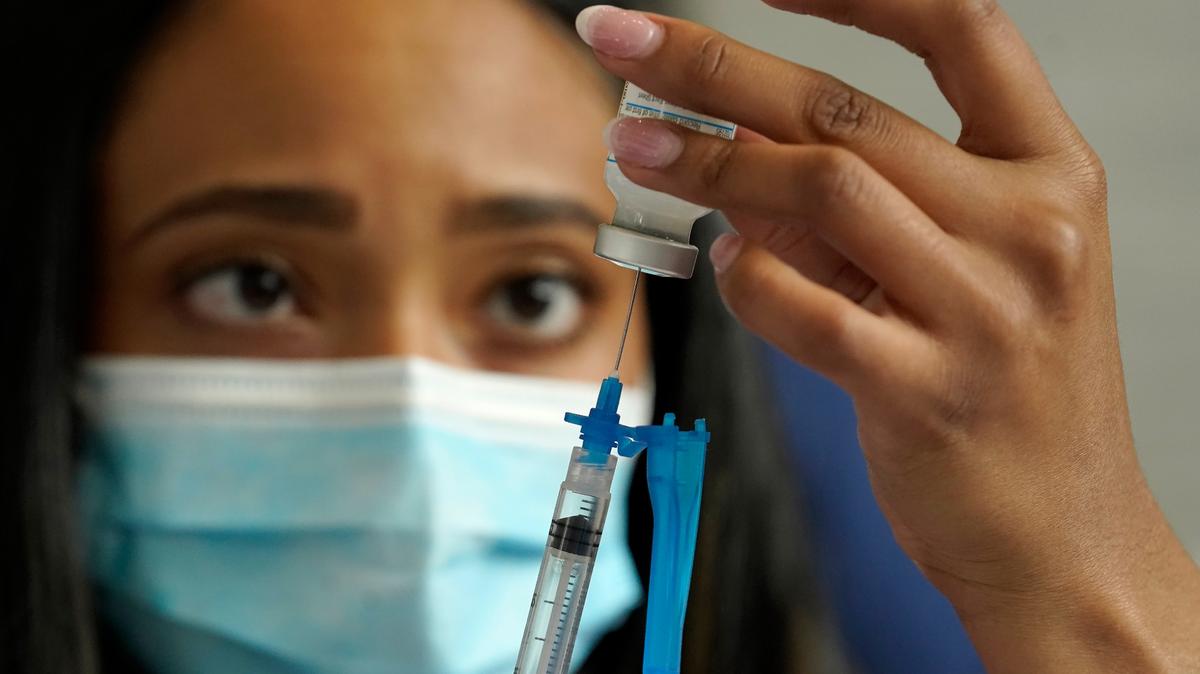 FILE - Licensed practical nurse Yokasta Castro, of Warwick, R.I., draws a Moderna COVID-19 vaccine into a syringe at a mass vaccination clinic, Wednesday, May 19, 2021, at Gillette Stadium, in Foxborough, Mass. (AP Photo/Steven Senne)