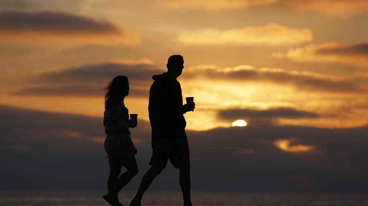 La Jolla Coastline Sunset In San Diego. A couple walk along the La Jolla coast at sunset on a warm, summer evening on August 3, 2025 in San Diego, California.  