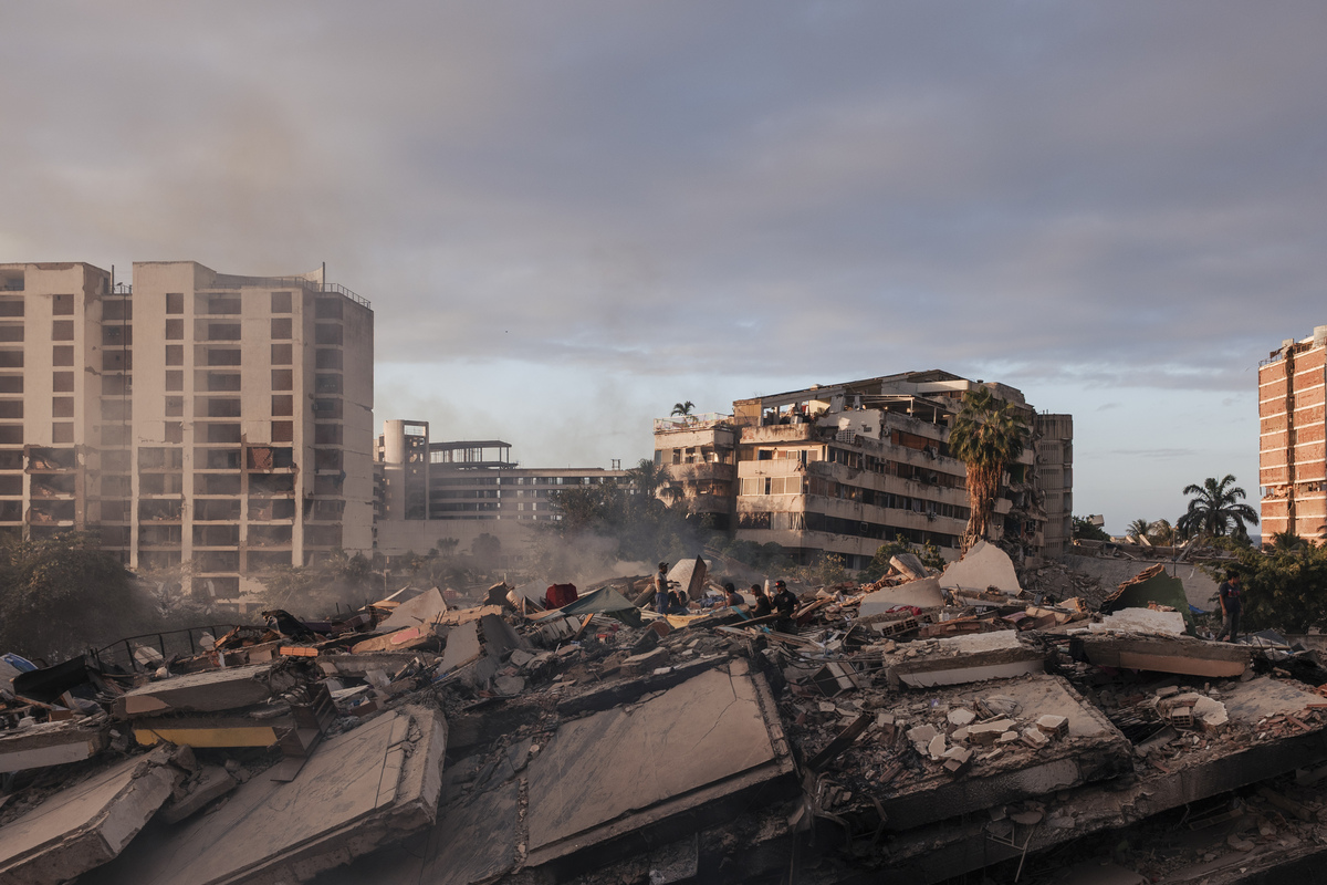 Civilians set up improvised tents on the roofs of buildings to search for their relatives in Caribe, Venezuela, June 27, 2026. As the death toll mounts, thousands of bodies have overwhelmed Venezuela's forensic system, turning a seaport into a temporary morgue. (Adriana Loureiro Fernandez/The New York Times)