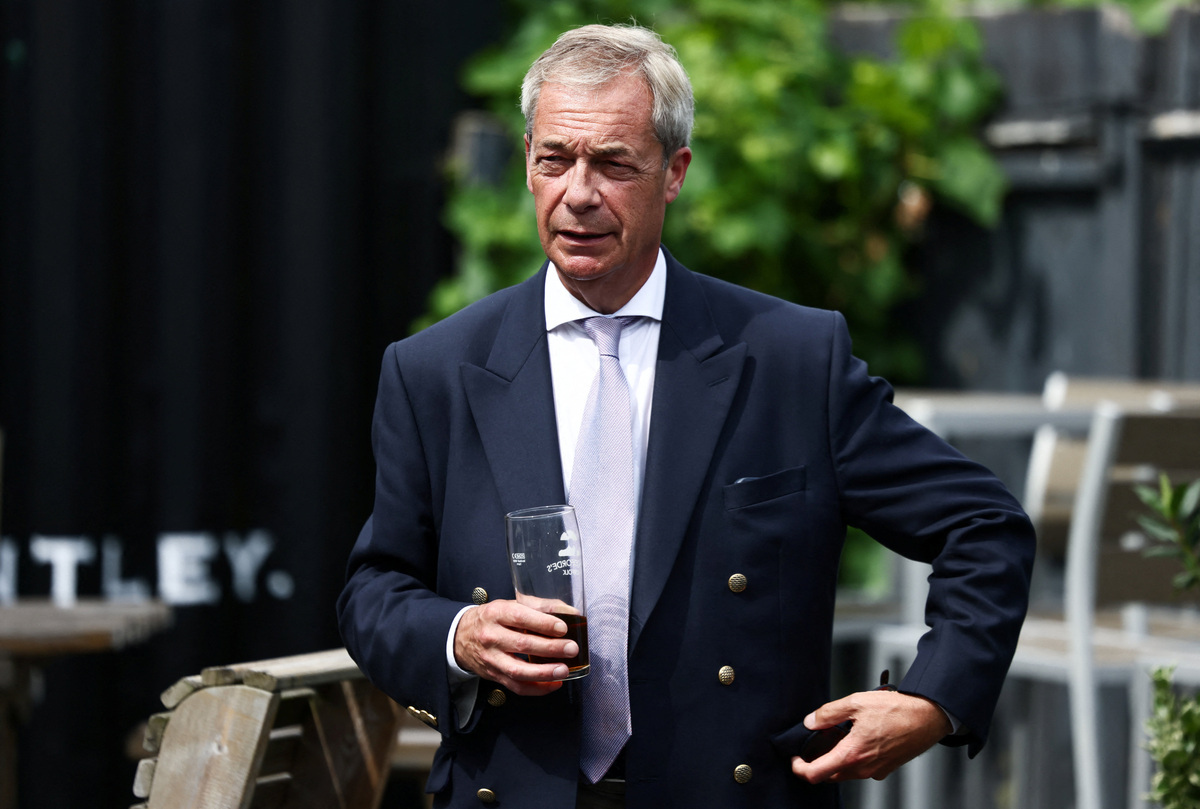 Leader of the Reform UK party Nigel Farage holds a glass at a pub, after he announced on Tuesday that he has resigned as an MP, triggering a by-election in his parliamentary seat, where he intends to stand for re-election, in Great Bentley, Britain, July 8, 2026. REUTERS/Jack Taylor