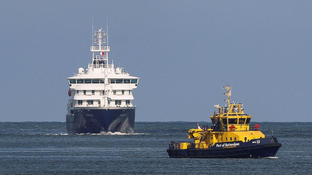 A patrol vessel sails near the cruise ship MV Hondius, which was affected by a hantavirus outbreak, as it arrives for disinfection at the Port of Rotterdam, Netherlands, May 18, 2026. REUTERS/Yves Herman