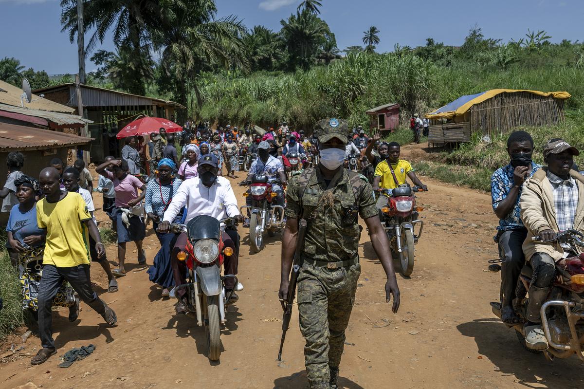 A soldier escorts the crowd of people who had tried to retrieve the body of Rev. Sylvestre Atama, a popular and charismatic preacher who died of Ebola, in the mining town of Mongbwalu, Democratic Republic of Congo, May 25, 2026. In a remote gold mining town at the epicenter of the Ebola outbreak, medical workers struggle to beat back a surge of deaths and infections. (Arlette Bashizi/The New York Times)