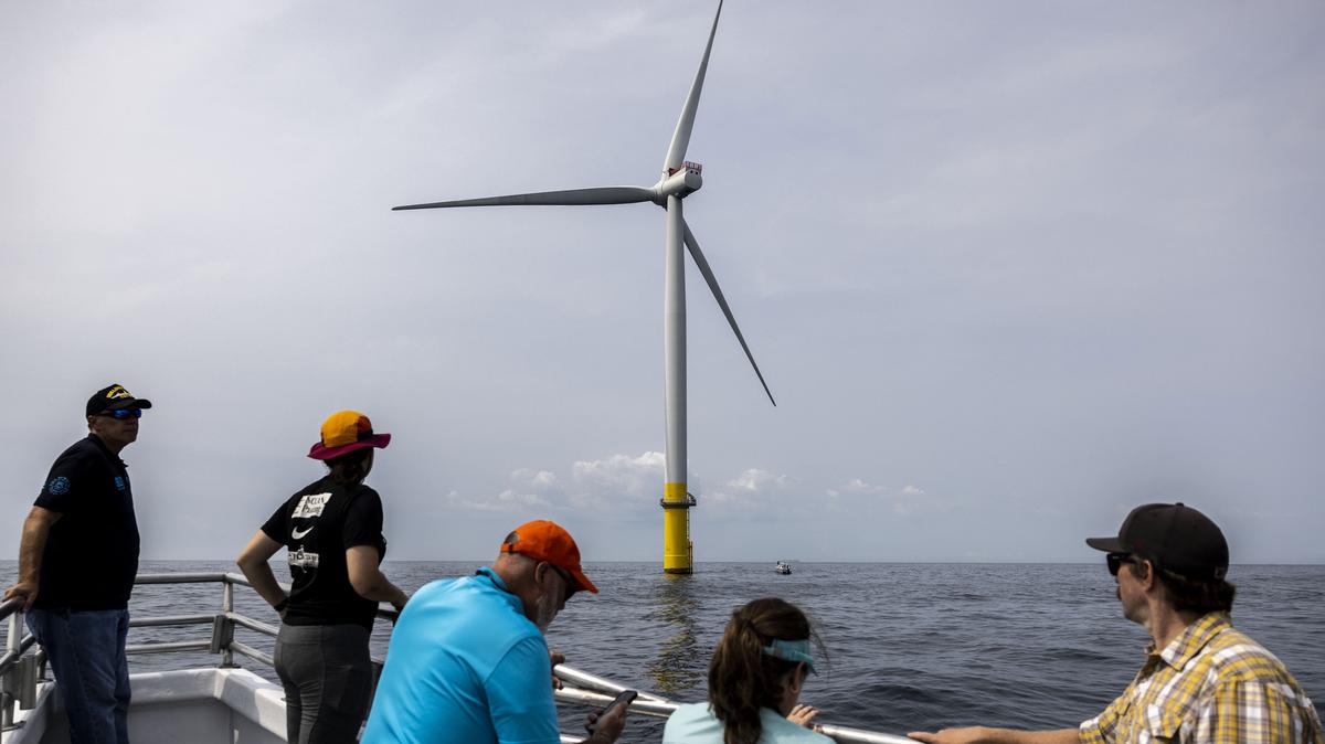 Employees of Dominion Energy gaze at one of two wind turbines located 27 miles off Virginia Beach, Virginia, on July 17, 2023. The U.S. Interior Department on Monday said it will pay a total of $885 million to Bluepoint Wind and Golden State Wind to voluntarily end their offshore wind leases, with both agreeing to instead invest in “reliable conventional energy projects.”