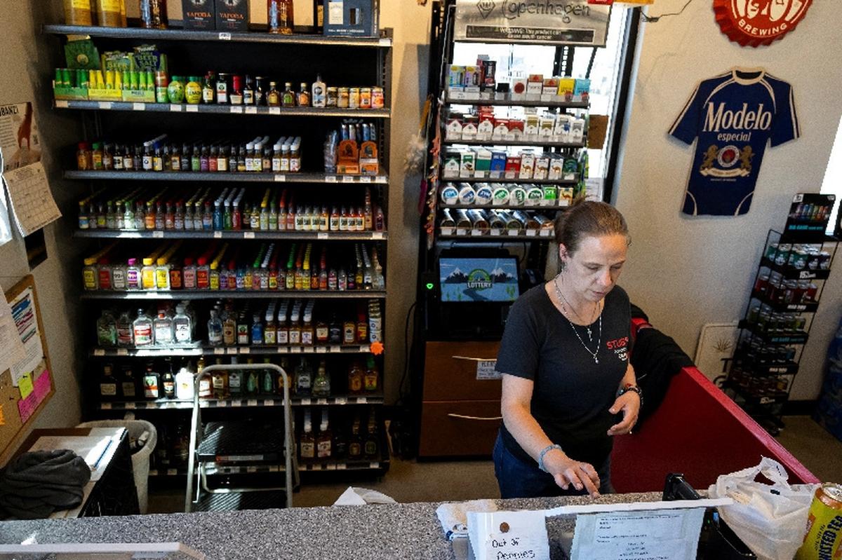 Tanya Bruyette checks out a customer at the liquor store where she works in Wiggens, Colorado, U.S., May 11, 2026.  REUTERS/Kevin Mohatt