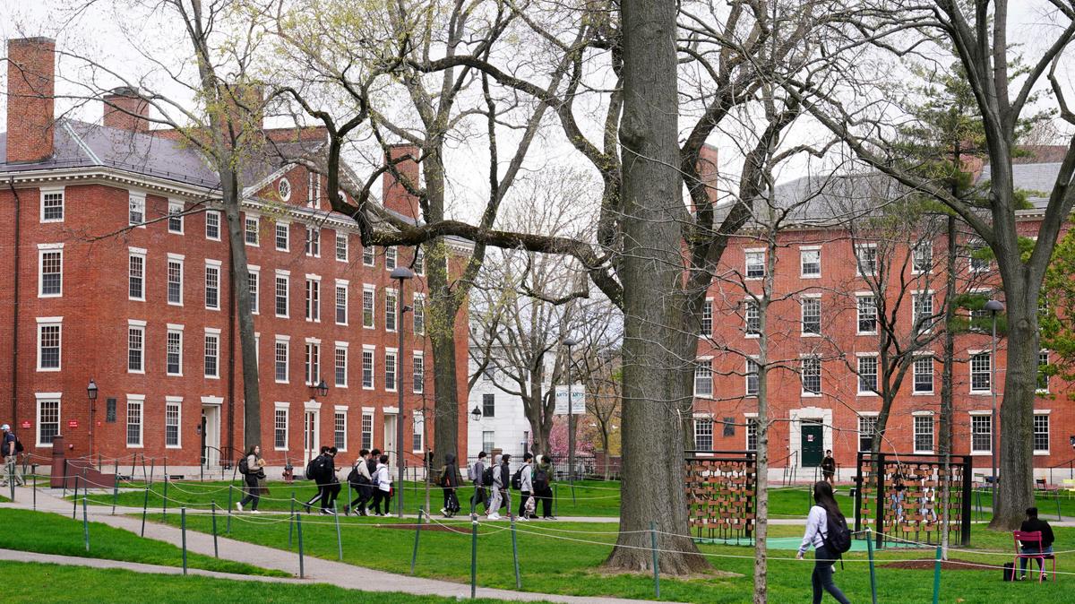Students walk through Harvard Yard, on April 27 on the campus of Harvard University in Cambridge, Mass.
