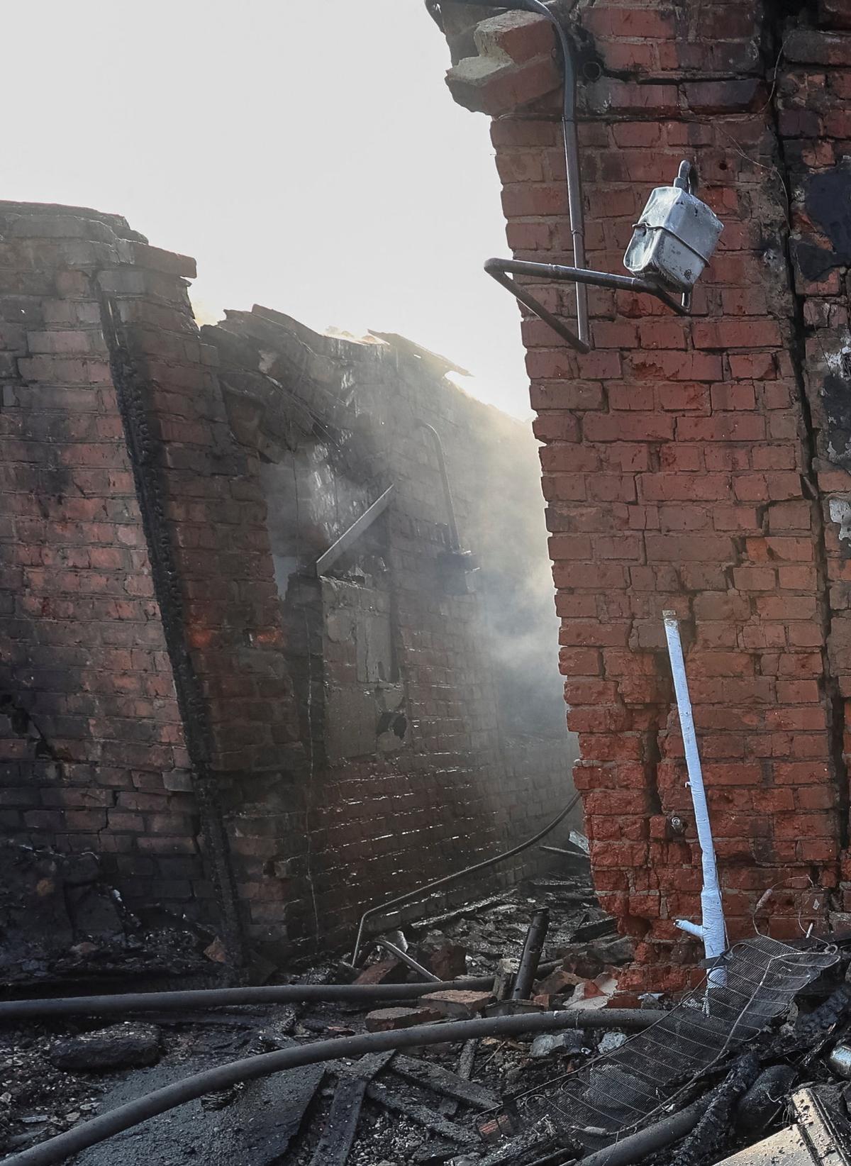 A rescuer works at the site of the private house hit by a Russian drone strike as the engine of a Russian drone lies on the ground, amid Russia's attack on Ukraine, in Kharkiv, Ukraine May 6, 2026.  REUTERS/Vyacheslav Madiyevskyy