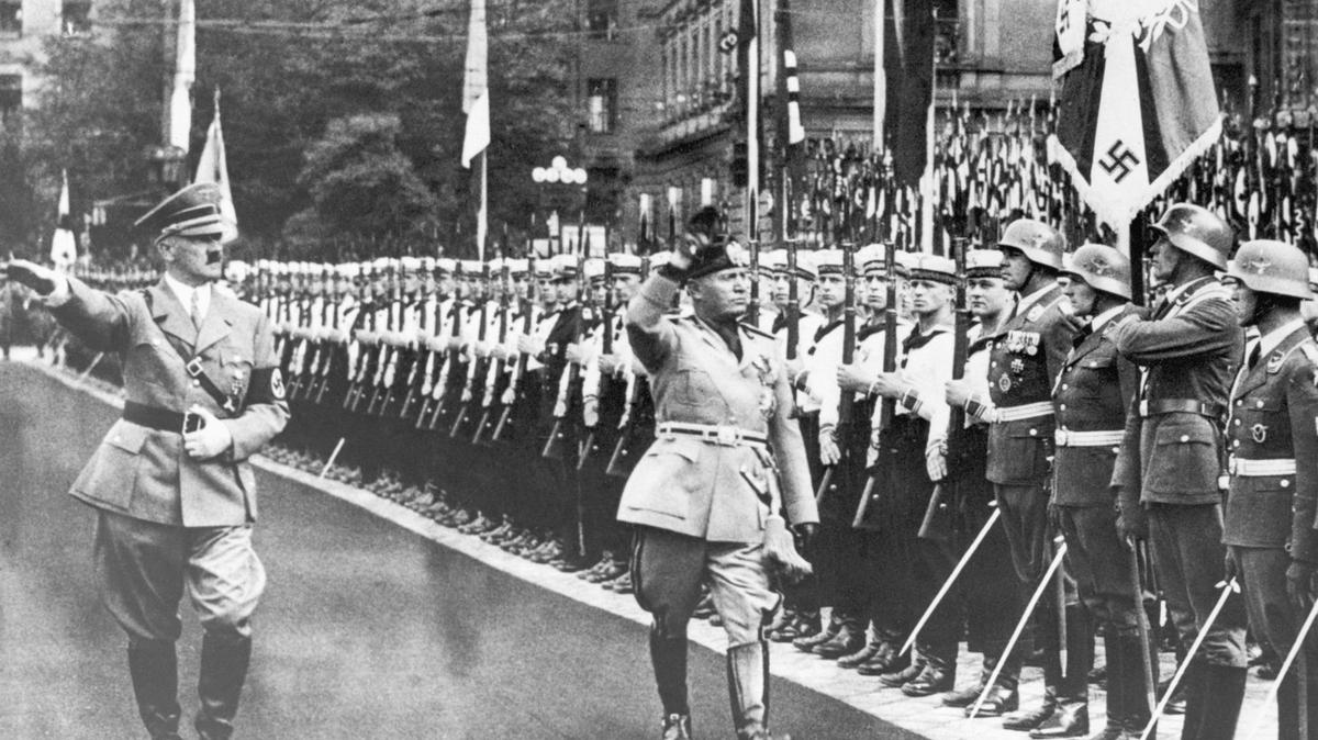 Hitler and Mussolini salute Nazi troops in 1937. Bettmann/Getty Images. 