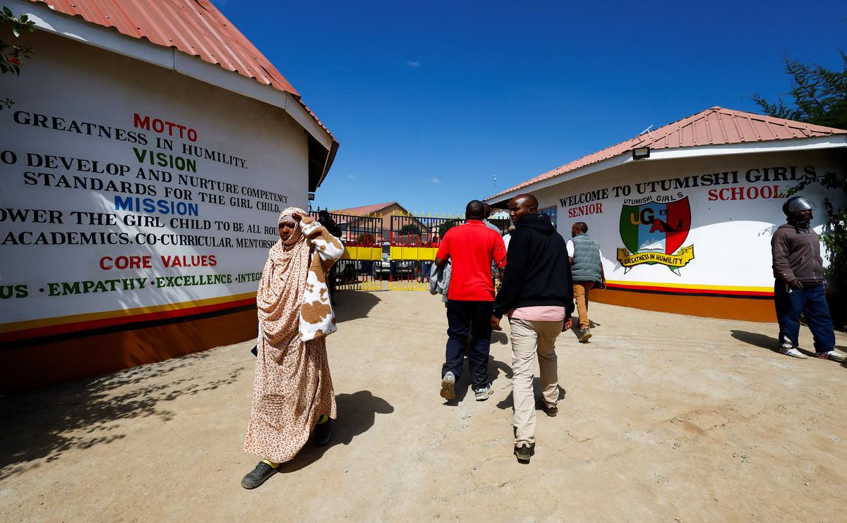 Parents and residents walk at the main entrance of Utumishi Girls' Academy Senior School following an overnight fire in a dormitory at the facility in Gilgil, Nakuru county, Kenya May 28, 2026. REUTERS/Thomas Mukoya