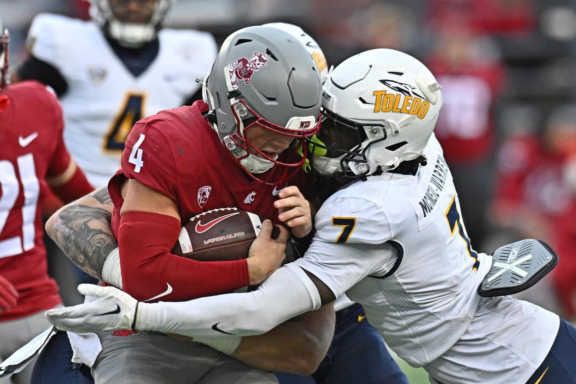  Oct 25, 2025; Pullman, Washington, USA; Washington State Cougars quarterback Zevi Eckhaus (4) is tackled by Toledo Rockets safety Emmanuel McNeil-Warren (7) in the second half at Gesa Field at Martin Stadium. Mandatory Credit: James Snook-Imagn Images 
