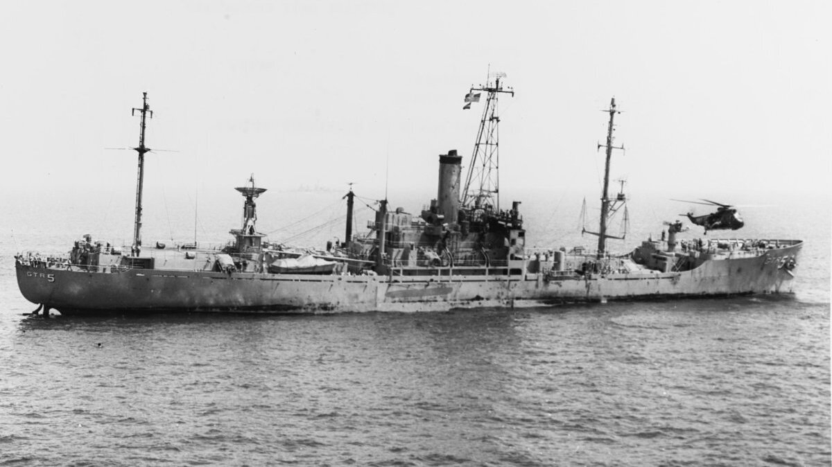 The USS Liberty (AGTR-5) receives assistance from units of the Sixth Fleet, after she was attacked and seriously damaged by Israeli forces off the Sinai Peninsula on June 8 1967. An SH-3 helicopter is near her bow. File Photo courtesy U.S Navy