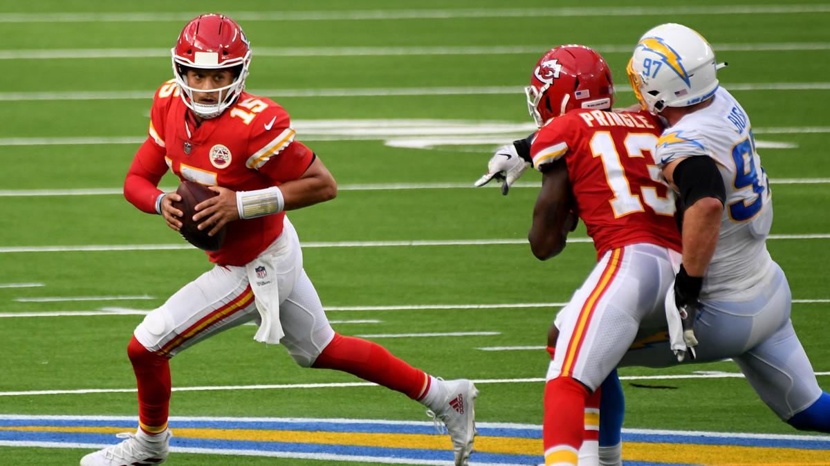 Quarterback Patrick Mahomes, left, of the Kansas City Chiefs scrambles against the Los Angeles Chargers in the second half of an NFL football game at SoFi Stadium in Inglewood, Calif., on Sunday, Sept. 20, 2020. Kansas City Chiefs won 23-20 in overtime. (Keith Birmingham/The Orange County Register via AP)