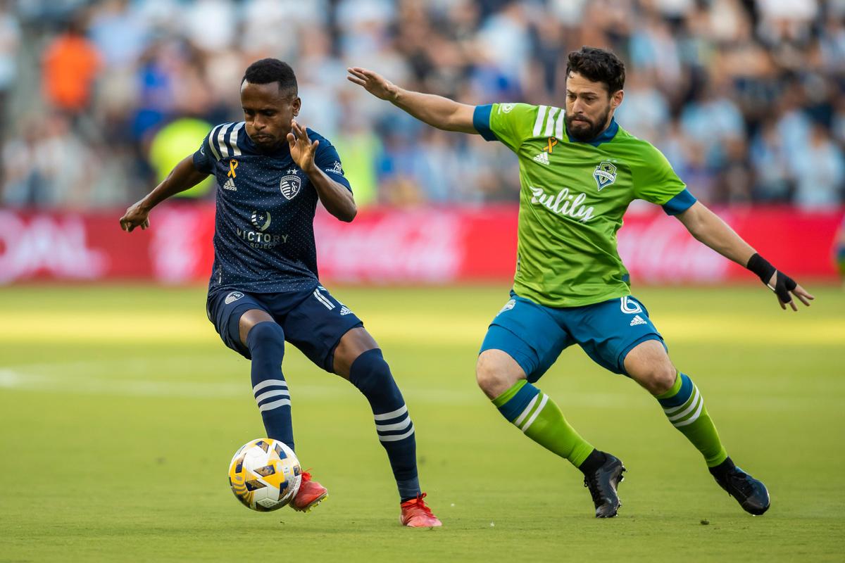 Midfielder Gadi Kinda, left, played for Sporting Kansas City in 2021, works his way around Seattle Sounders midfielder Joao Paulo.