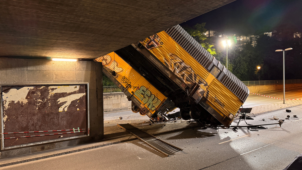 Two cars of a freight train which derailed after a collision, fell off a bridge and lay on a road in Munich, Germany, June 20, 2026.   REUTERS/Christine Uyanik