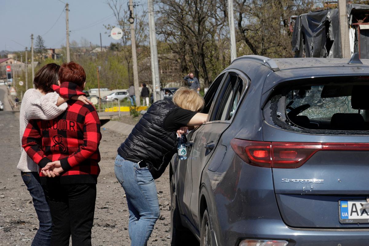 Residents react next to a car with the body of their relative inside who was killed by a Russian missile strike in the town of Merefa, amid Russia's attack on Ukraine, in Kharkiv region, Ukraine May 4, 2026. REUTERS/Sofiia Gatilova