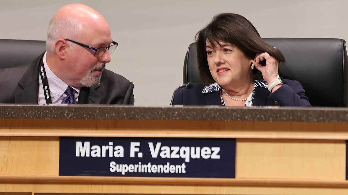 Orange County School Superintendent Maria Vazquez chats with general counsel John Palmerini (left) during a board meeting in Orlando on Tuesday, Aug. 12, 2025. On Tuesday, Vazquez told the board that putting teacher pay raises on the school tax referendum would cause "hundreds" of job cuts. (Stephen M. Dowell/Orlando Sentinel)