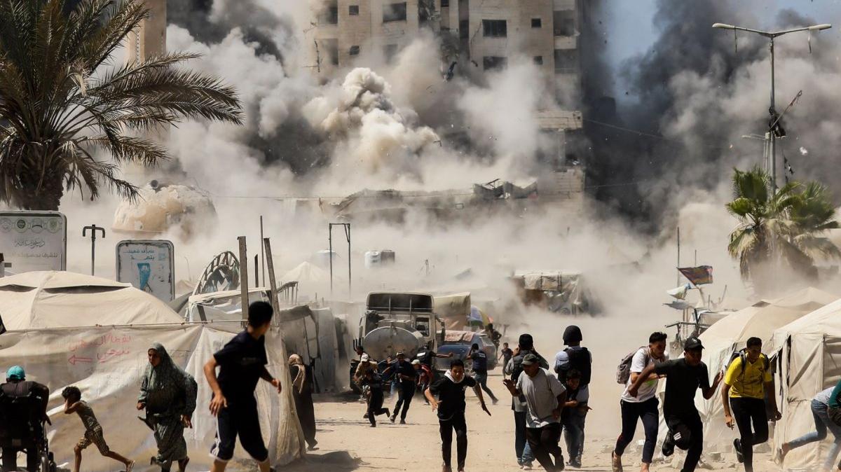 Palestinians run as smoke billows from the Mushtaha Tower after an Israeli airstrike shortly after the Israeli military announced its intention to target high-rise buildings in Gaza City on Sept. 5. An airstrike in Gaza City hit a residential building Tuesday and killed at least three Palestinians while injuring dozens more. File Photo by Omar Ishtiwi/UPI