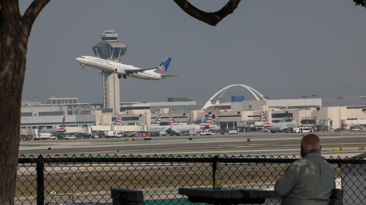 A spectator watches as a United Airlines flight takes off, as seen from Clutter's Park on Sunday, Oct. 26, 2025, in El Segundo, Calif. (Juliana Yamada/Los Angeles Times/TNS)