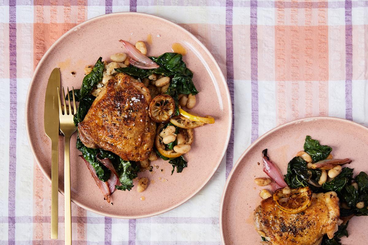 Skillet chicken with white beans and caramelized lemon. Alison Roman tosses white beans and kale into the hot skillet that's already housing caramelized shallot and lemon slices. Food styled by Alison Roman. (Michael Graydon & Nikole Herriott/The New York Times)