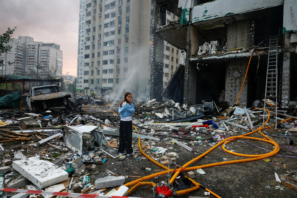 A resident reacts while she waits for rescuers who are searching for her relative inside an apartment building, which was hit during Russian missile and drone strikes, amid Russia's attack on Ukraine, in Kyiv, Ukraine, July 6, 2026. REUTERS/Valentyn Ogirenko
