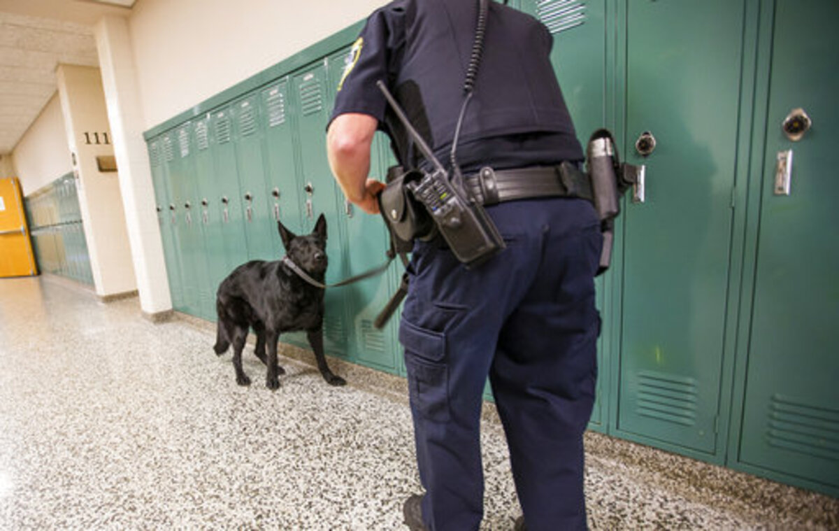 A police officer and drug-sniffing dog patrol an Indiana school in this file photo. The Chapel Hill-Carrboro City Schools has suspended suspicionless searches using drug-sniffing police dogs after complaints from a civil rights group.
