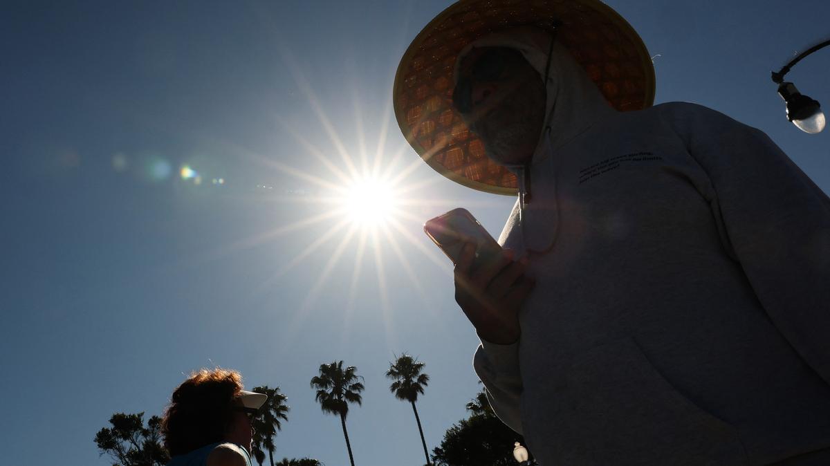 Una persona lleva un sombrero para protegerse del sol matutino mientras camina por The Strand, en Redondo Beach (California), el viernes 20 de marzo de 2026, durante una ola de calor. (Patrick T. Fallon/AFP/Getty Images/TNS)