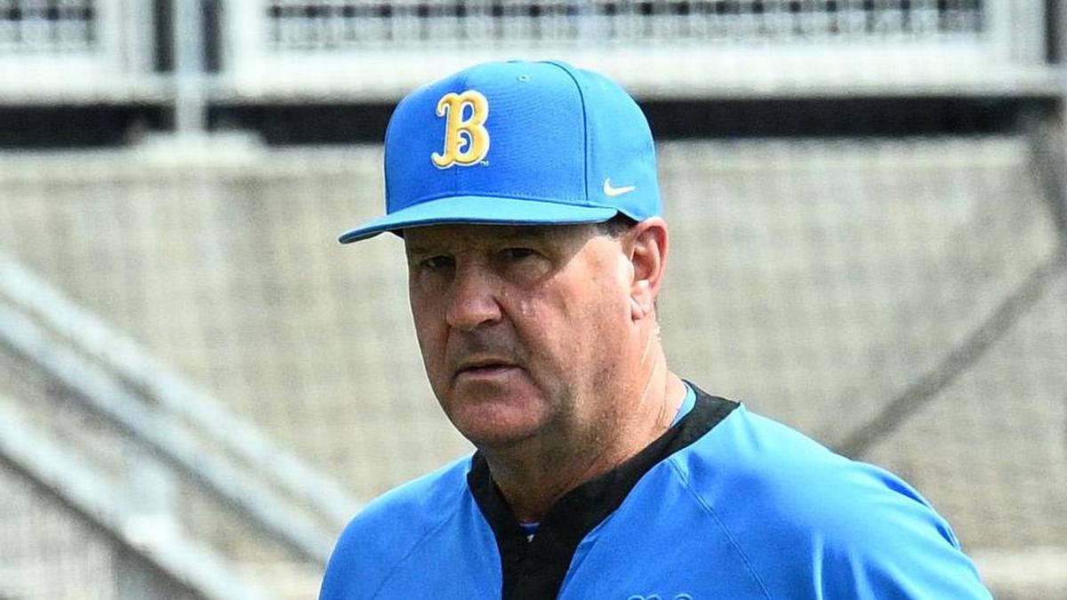  Jun 17, 2025; Omaha, Neb, USA; UCLA Bruins head coach John Savage (22) walks to the dugout before the restart of the game against the LSU Tigers at Charles Schwab Field. Mandatory Credit: Steven Branscombe-Imagn Images | Steven Branscombe-Imagn Images 