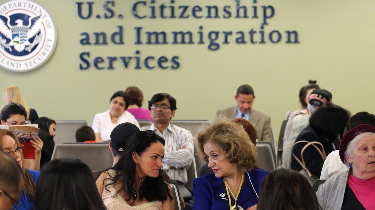 Inmigrantes esperan su turno para entrevistas de residencia permanente y ciudadanía en la oficina de USCIS en Queens, Nueva York. La imagen refleja la creciente demanda de trámites migratorios en medio de los cambios impulsados por el gobierno de Trump y su nueva campaña de contratación en inmigración.