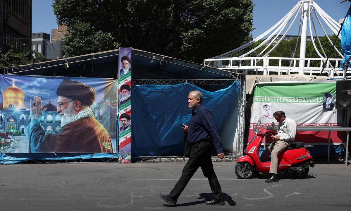 A man walks past a banner with a picture of Iran's late Supreme Leader Ayatollah Ali Khamenei, in Tehran, Iran, May 25, 2026. Majid Asgaripour/WANA (West Asia News Agency) via REUTERS
