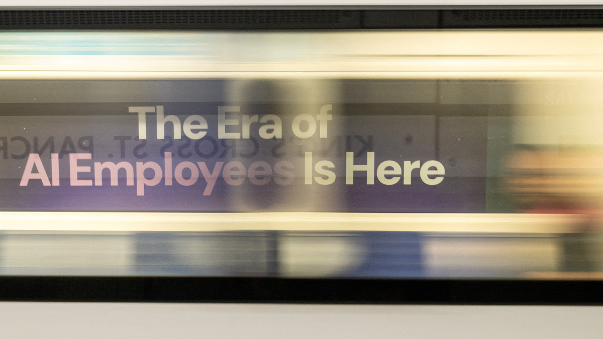 FILE PHOTO: A London underground train passes a billboard for an Artificial Intelligence company advertising AI employees in London, Britain, June 5, 2025. REUTERS/Chris J. Ratcliffe/File Photo