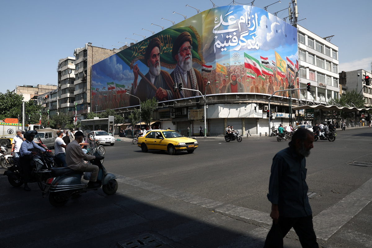 People walk past a billboard depicting the late leader of the Islamic Revolution, Ayatollah Ruhollah Khomeini, and the late Iran's Supreme Leader Ayatollah Ali Khamenei, on a street in Tehran, Iran, June 10, 2026. Majid Asgaripour/WANA (West Asia News Agency) via REUTERS