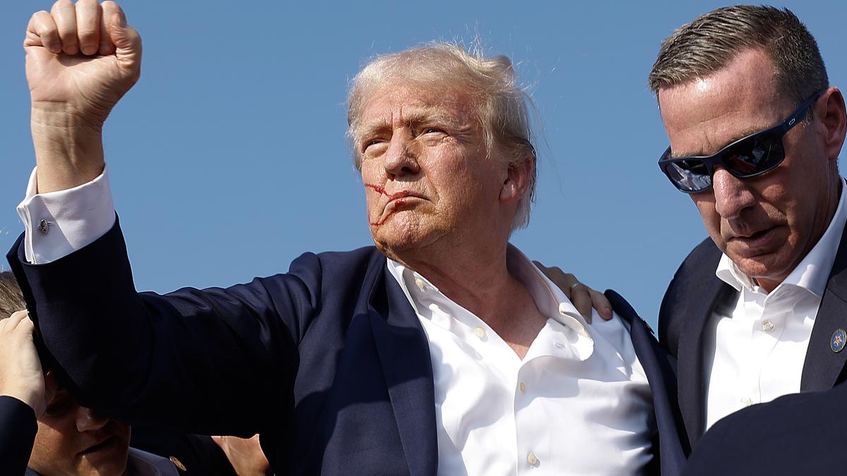 Republican presidential candidate former President Donald Trump pumps his fist as he is rushed offstage by Secret Service agents after being grazed by a bullet during a campaign rally on Saturday, July 13, 2024, in Butler, Pennsylvania. (Anna Moneymaker/Getty Images/TNS)