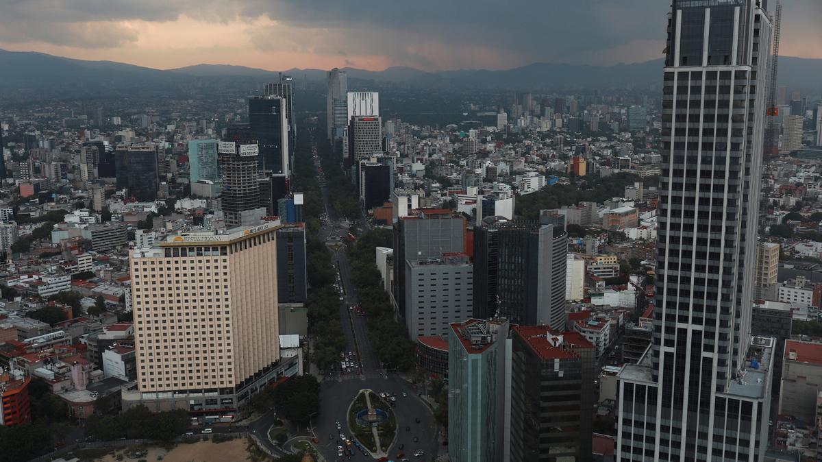 A view of Mexico city's skyline during a sunset as cars are pictured along Reforma Avenue in Mexico City, Mexico in this picture taken through glass in a building, May 24, 2023. REUTERS/Henry Romero