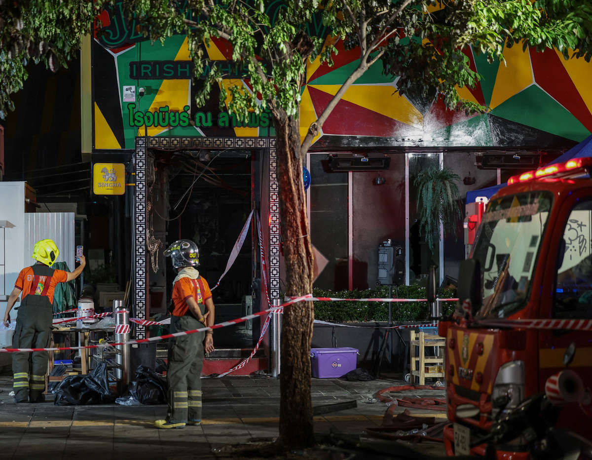 Members of emergency services work outside a pub where a deadly fire broke out, in Bangkok, Thailand, July 13, 2026. REUTERS/Chalinee Thirasupa