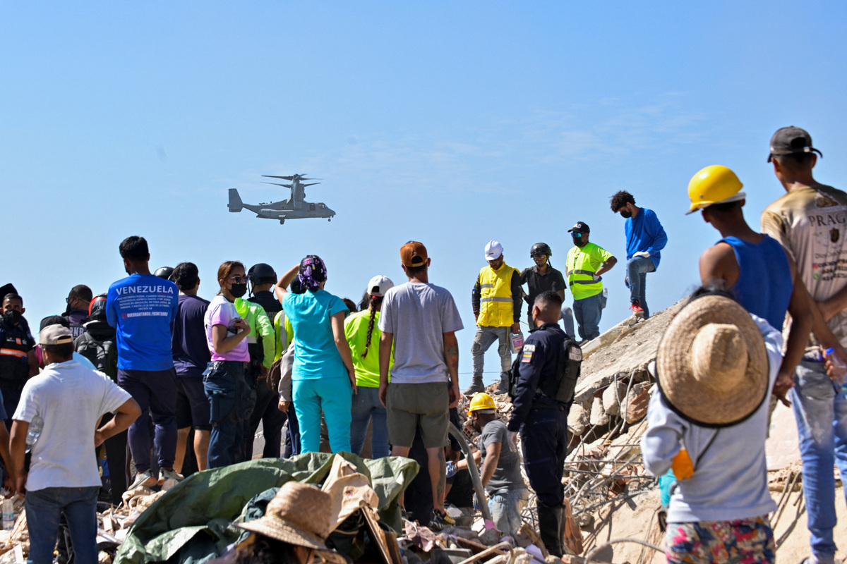People gather as rescue personnel assist in rescue efforts after earthquakes hit the country, in La Guaira, Venezuela, June 27, 2026. REUTERS/Maxwell Briceno