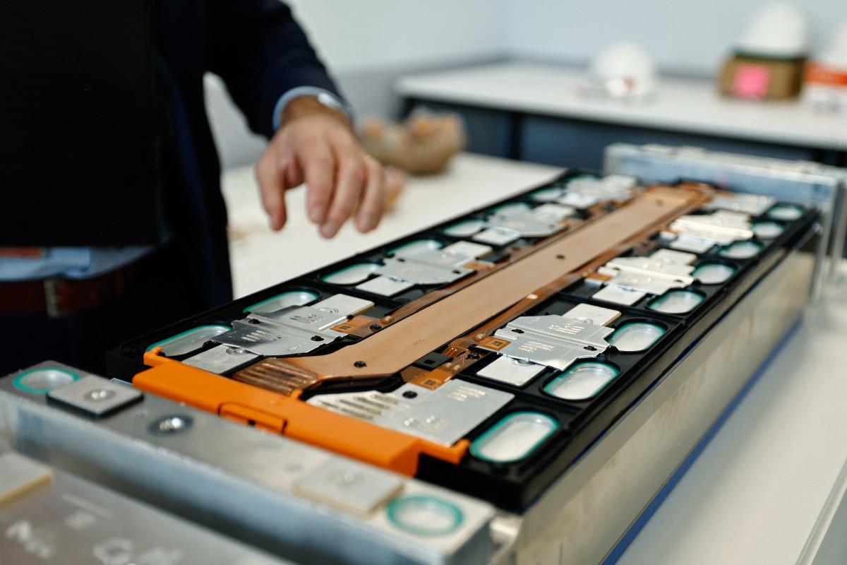 An employee shows a battery at the Automotive Cells Company (ACC) Gigafactory, which produces lithium-ion batteries for electric vehicles (EVs), in Douvrin, northern France