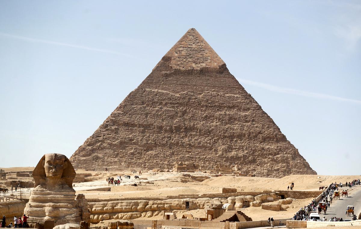 FILE PHOTO: Visitors are seen next to the Sphinx and the Great Pyramid at the Giza Plateau, on the outskirts of Cairo, Egypt, November 1, 2021. REUTERS/Mohamed Abd El Ghany/File Photo