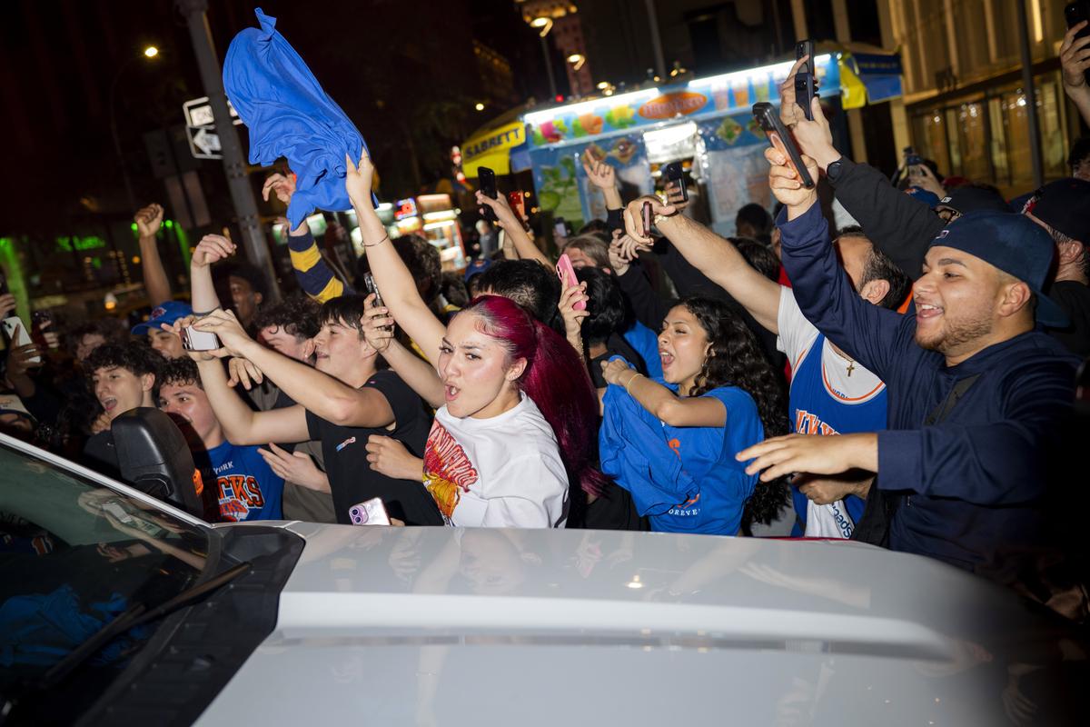 Jubilant Knicks fans celebrate outside Madison Square Garden in New York after their team swept the Cleveland Cavaliers in the Eastern Conference Finals to advance to the NBA Finals for the first time since 1999 on Monday night, May 25, 2026. Thousands of fans blocked traffic outside Madison Square Garden, even though the game was in Ohio and the outdoor watch parties at the Garden had been suspended because of rowdy fans. (Vincent Alban/The New York Times)
