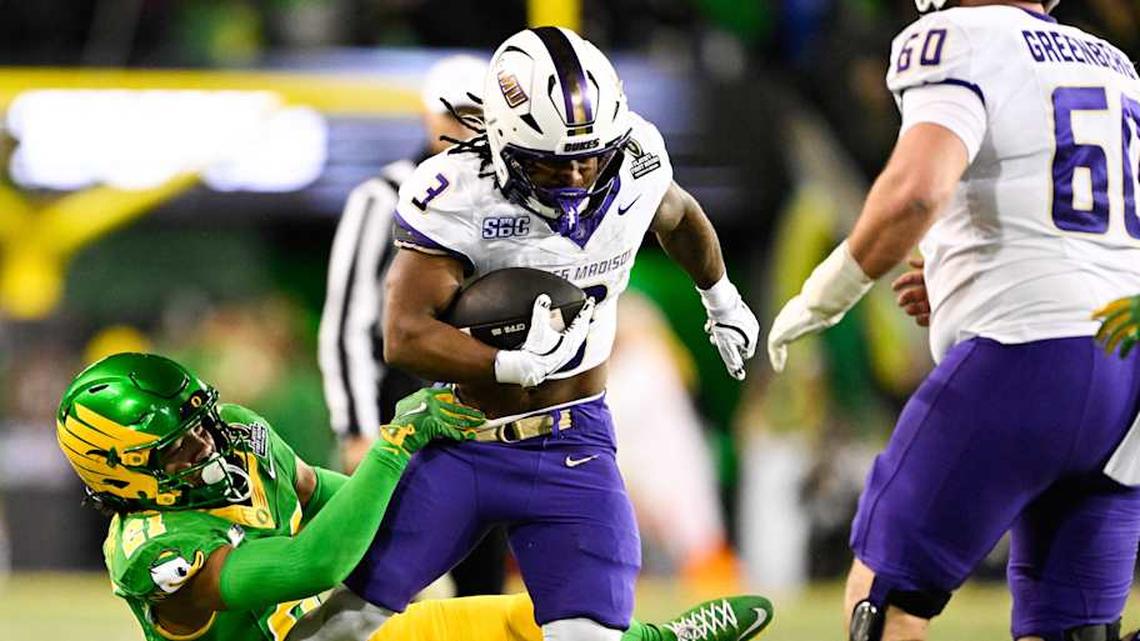  Dec 20, 2025; Eugene, OR, USA; James Madison Dukes running back Wayne Knight (3) rushes as Oregon Ducks defensive back Aaron Flowers (21) defends during the second quarter at Autzen Stadium. Mandatory Credit: Troy Wayrynen-Imagn Images | Troy Wayrynen-Imagn Images 