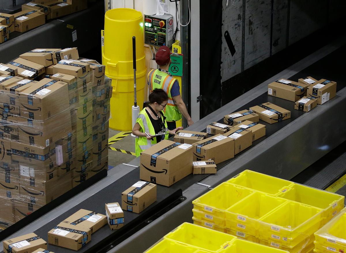 FILE - In this Feb. 9, 2018, file photo packages move down a conveyor system were they are directed to the proper shipping area at the new Amazon Fulfillment Center in Sacramento, Calif.