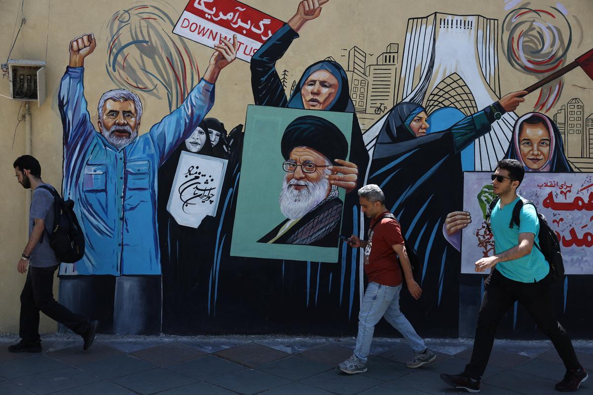 People walk on a street near a mural featuring an image of the late Supreme Leader of Iran, Ayatollah Ali Khamenei, in Tehran, Iran, May 11, 2026. Majid Asgaripour/WANA (West Asia News Agency) via REUTERS
