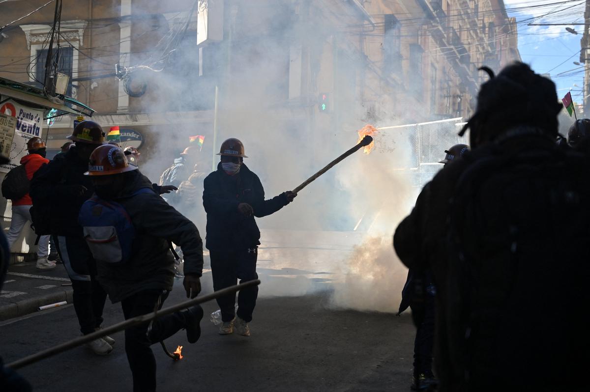 Demonstrators from mining unions react to tear gas fired by police forces as they protest against President Rodrigo Paz's government amid an ongoing economic and fuel crisis, in La Paz, Bolivia, May 14, 2026. REUTERS/Claudia Morales