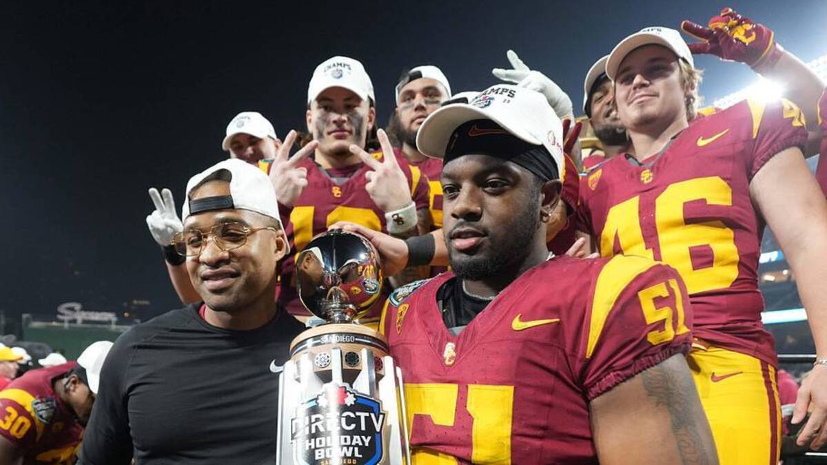  Dec 27, 2023; San Diego, CA, USA; Southern California Trojans director of player development Chris Carter (left) and defensive end Solomon Byrd (51) hold the Holiday Bowl championship trophy at Petco Park. Mandatory Credit: Kirby Lee-Imagn Images | Kirby Lee-Imagn Images 