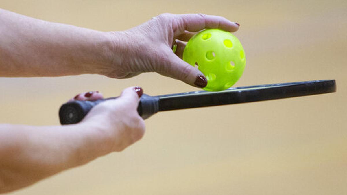 This Wednesday, Dec 18, 2019, photo shows a racket and ball used in a pickleball game at the Lynnhurst Recreation Center in Minneapolis. The game is a hybrid of racket and paddle sports, with a net that looks a lot like a tennis net, a paddle-like ping pong and a Wiffle ball that has a bit of bounce.